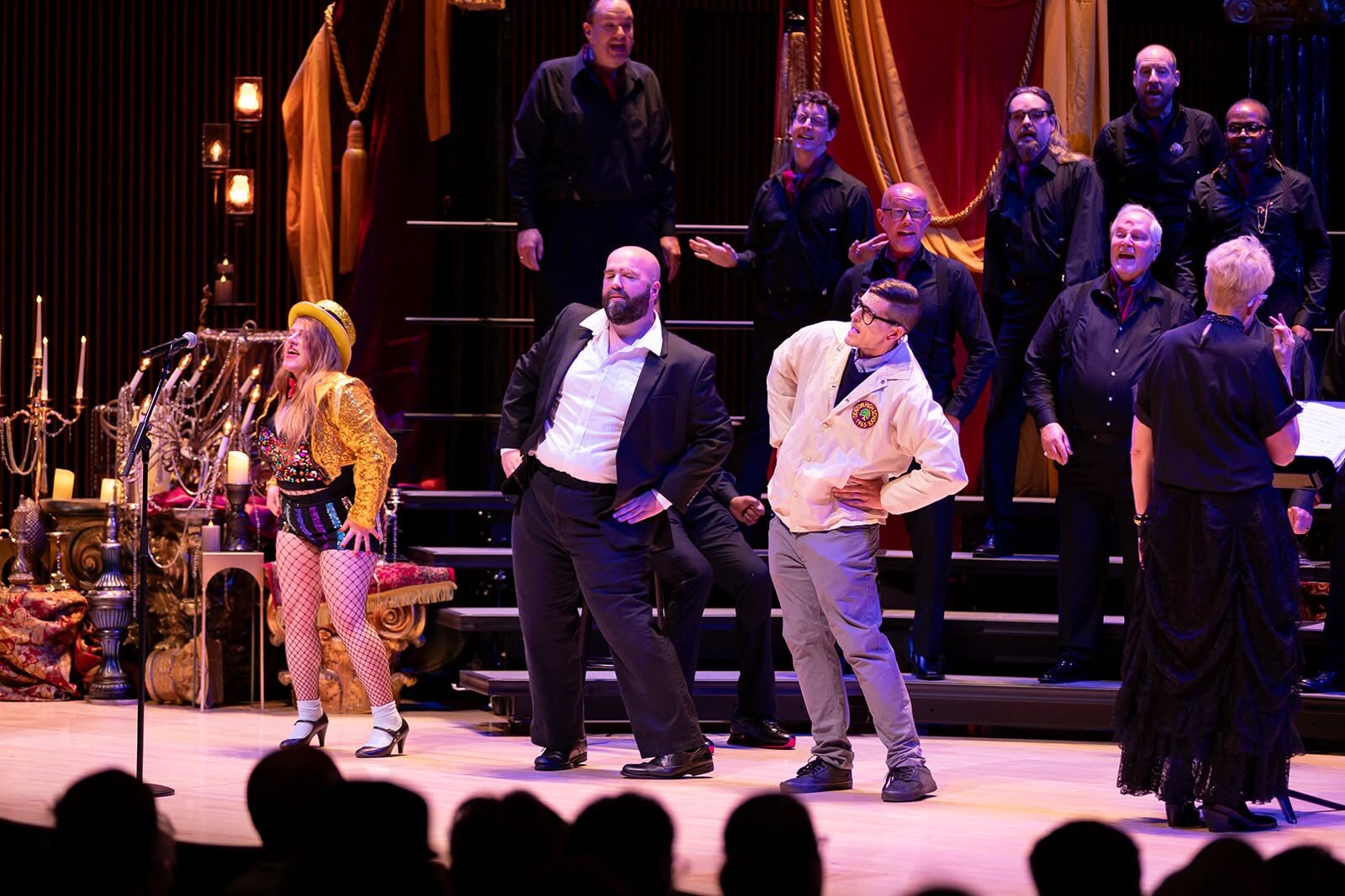 Cast performing on a concert hall stage with the Dayton Gay Men's Chorus