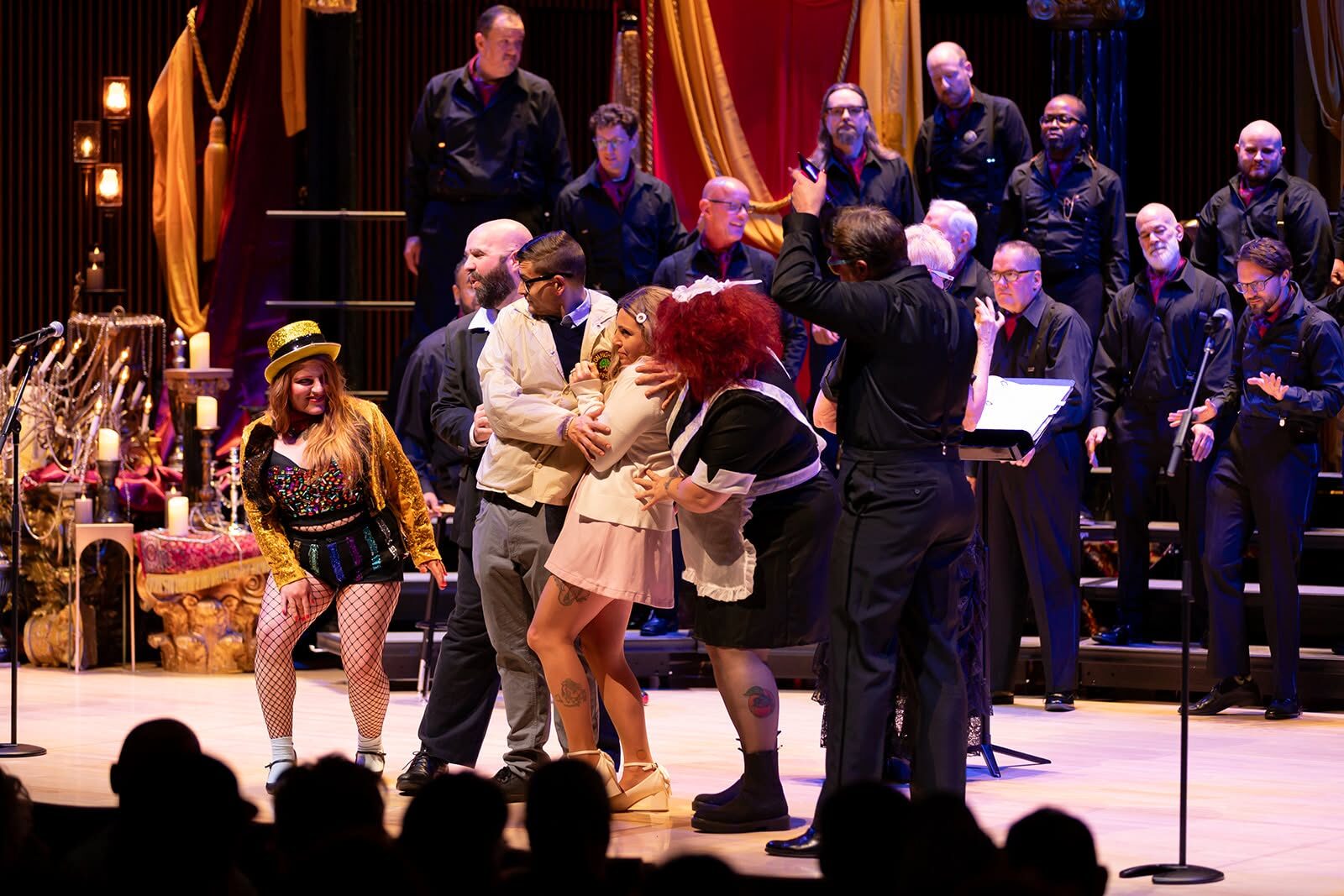 Cast members embracing on stage during the chorus performance