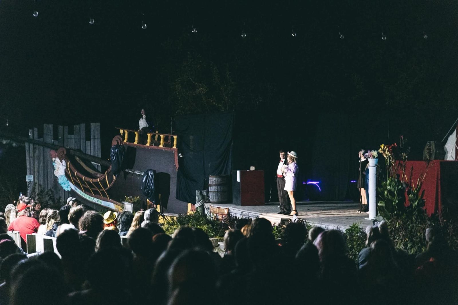 Night performance on the outdoor Renaissance Festival stage with a packed audience