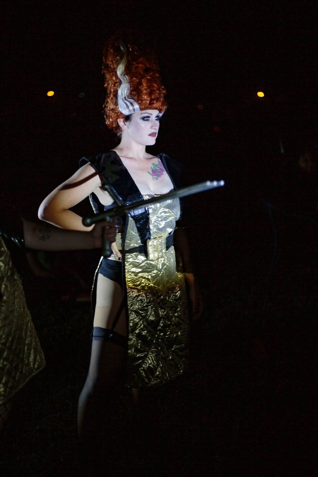 Magenta in a towering bride wig and gold space suit, ray gun in frame