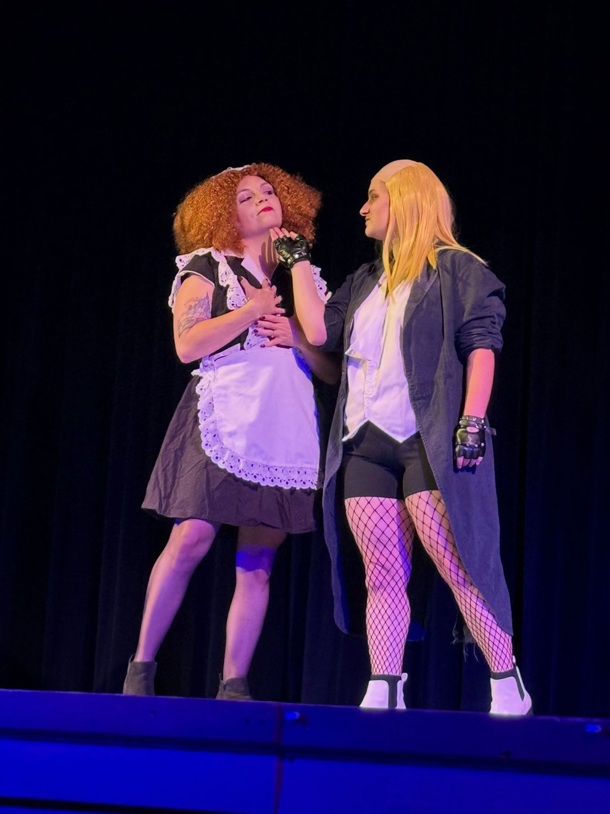 Magenta and Riff Raff on stage in purple light