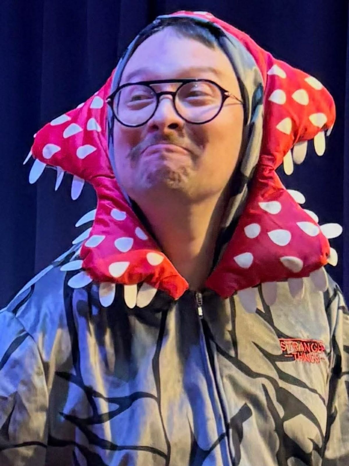 Cast member grinning inside a red Demogorgon hood